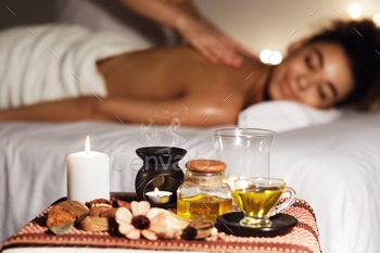 African woman having fun with aromatherapy massage in luxury spa