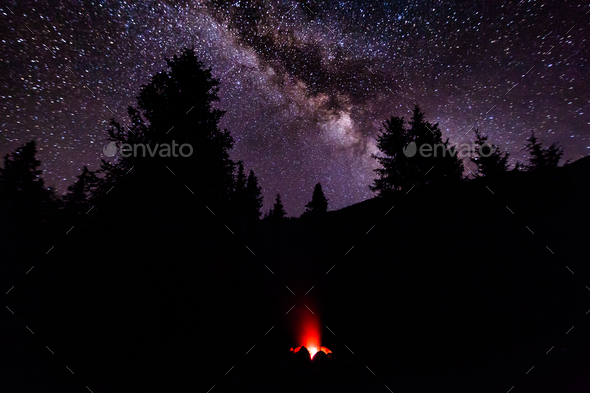 A hearth in the camp in the forest less than a starry sky. Milky Way