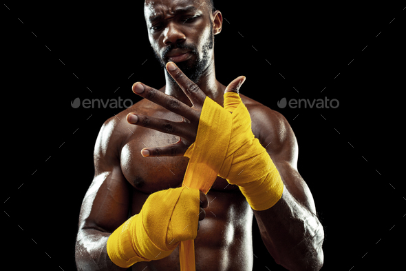 Afro American boxer is wrapping hands with bandage
