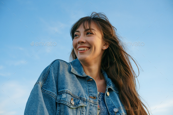 Portrait of a young woman against the sky